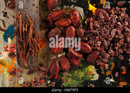 raw cacao nibs, shredded chocolate and cocoa beans  on vintage painted background Stock Photo