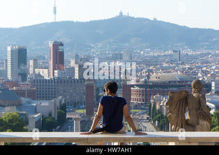 Male tourist taking a break in front of Museu Nacional d'Art de Catalunya facing Plaza de España Stock Photo