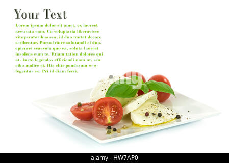 Delicacy of Italian cuisine - mozzarella cheese with basil leaves and baby tomatoes, flavored with olive oil and pepper, isolated on a white backgroun Stock Photo