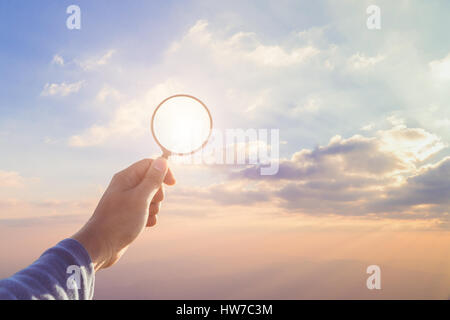 Hand hold magnifying glass,Searching concept,Business success research concept,Travel accessories,Daylight flare and vintage color tone. Stock Photo