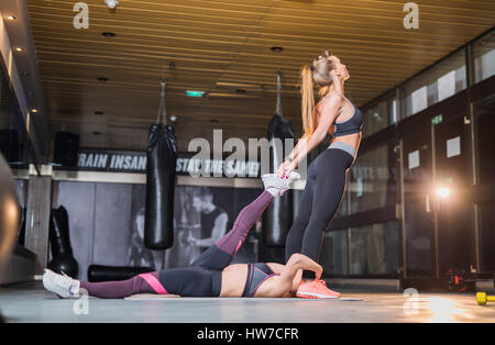 Two young athletic women doing pilates stretching exercise Stock Photo