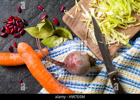 Beets, carrots and cabbage during cooking. Composition on a dark background. Place for text. Stock Photo