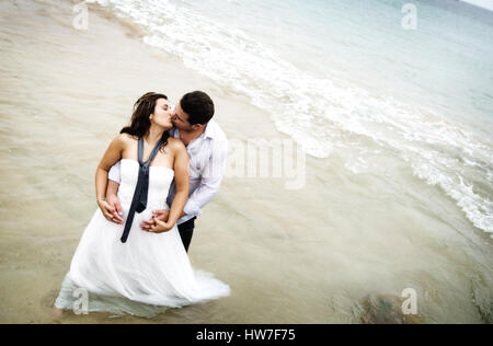 Groom´s couple in the seawater, kissing and hugging Stock Photo