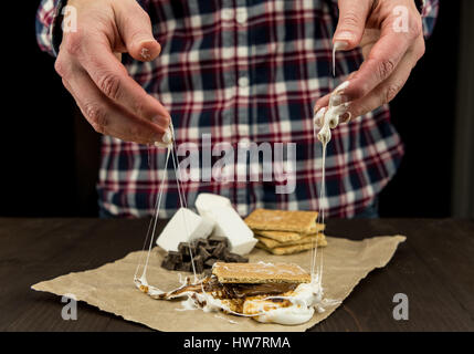 Womans Hands With Sticky Melted Marshmallow and Smore stuck to her fingers Stock Photo