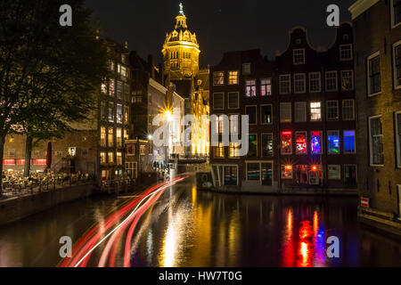 AMSTERDAM, NETHERLANDS- SEPTEMBER 26, 2016: Canal houses and the Church of St. Nicholas at night. Stock Photo