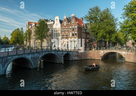 AMSTERDAM, NETHERLANDS- SEPTEMBER 27, 2016: Bridges, bikers and boaters at the intersection of the Keizersgracht and Leidsegracht Canals.