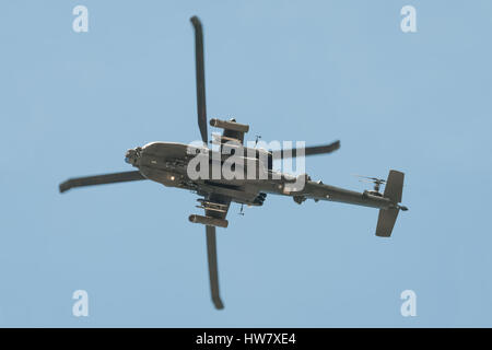 Underside of a Boeing AH-64 Apache helicopter gunship arriving at Farnborough, UK in a clear blue sky. Stock Photo