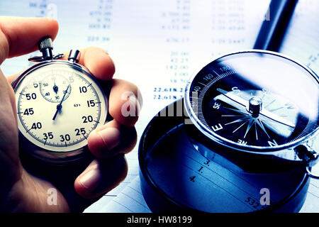 Hand holding stopwatch on budget numbers in closeup Stock Photo