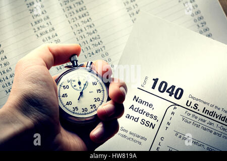 Hand holding stopwatch on budget numbers in closeup Stock Photo