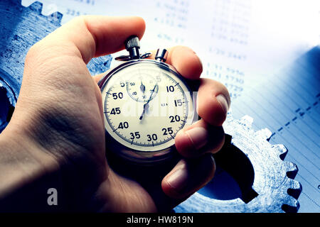Hand holding stopwatch on budget numbers in closeup Stock Photo