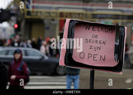 Amsterdam, Netherlands. 18th March 2017. An activist holds a sign that reads 'Welcome - The doors are open'. Around 2,000 people marched through Amsterdam, to protest against racism and discrimination. The protest was part of an European wide day of protest against the EU Turkey Refugee Deal and the International Day for the Elimination of Racial Discrimination (21. March). Credit: Michael Debets/Alamy Live News Stock Photo