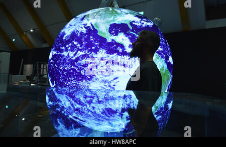 Potsdam, Germany. 17th Mar, 2017. An employee stands in front of an illuminated replica of planet Earth at the exhibition room of the 'Haus der Brandenburgisch-Preussischen Geschichte' (lit. 'House of the Brandenburgian-Prussian History') in Potsdam, Germany, 17 March 2017. On 23 March 2017, the exhibition 'Fokus: Erde. Von der Vermessung unserer Welt' (lit. 'Focus: Earth. On the measuring of our world') opens on the occasion of the 25th anniversary of the Helmholtz Center Potsdam - German Geo-Research Center (GFZ). Photo: Ralf Hirschberger/dpa-Zentralbild/dpa/Alamy Live News Stock Photo