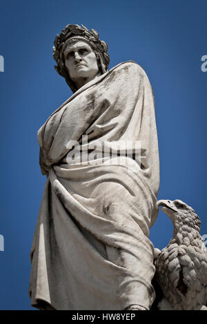 Statue of Dante Allighieri in Florence, Tuscany in the Piazza de Santa Croce with an eagle at his feet viewed from below against blue sky Stock Photo