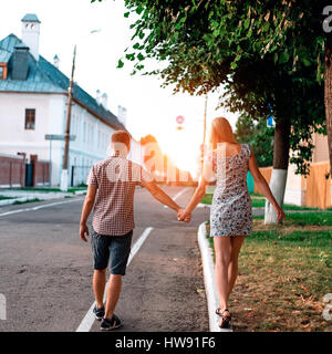 The guy holds his girlfriend by the hand, in summer in city goes on train, playfully, concept of relationships, the newlyweds. Lifestyle, the summer i Stock Photo