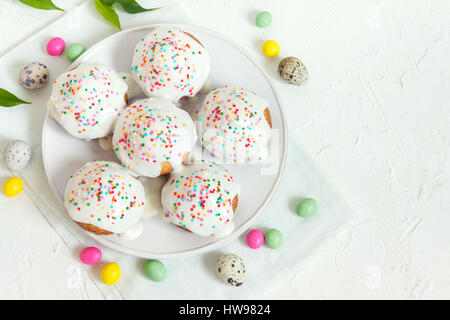 Easter pastry. Fresh Homemade Carrot Mini Cakes with White Creamy Sugar Icing and Colorful Decor. Easter Cakes for Easter Breakfast with Easter eggs a Stock Photo