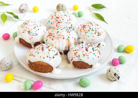 Easter pastry. Fresh Homemade Carrot Mini Cakes with White Creamy Sugar Icing and Colorful Decor. Easter Cakes for Easter Breakfast with Easter eggs a Stock Photo