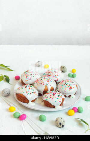 Easter pastry. Fresh Homemade Carrot Mini Cakes with White Creamy Sugar Icing and Colorful Decor. Easter Cakes for Easter Breakfast with Easter eggs a Stock Photo