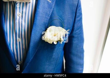 Yellow boutonniere pinned to a grooms jacket Stock Photo