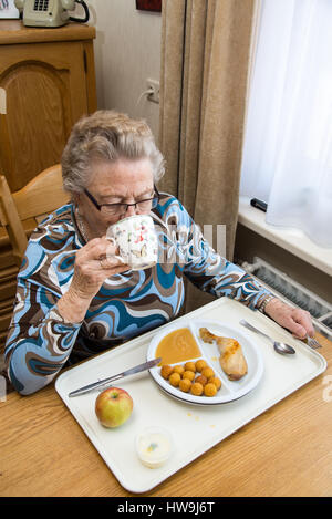 old woman eating at table in house of the elderly Stock Photo