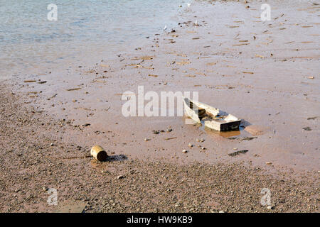 Damaged rotting small rowing boat in the mud in the River Teign in Teignmouth Devon England Stock Photo