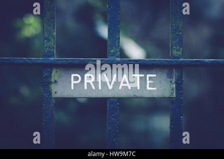 Private sign on wrought iron gates with an antique filter applied to the image useful for privacy or security concepts Stock Photo