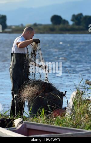France, Haute Corse, the pond of Biguglia (Stagnu di Chiurlinu), nature reserve of Corsica (RNC), fisherman cleaning his net Stock Photo