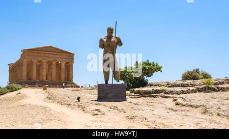 AGRIGENTO, ITALY - JUNE 29, 2011: statue and Temple of Concordia in Valley of the Temples in Sicily. This area has largest and best-preserved ancient  Stock Photo