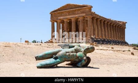 AGRIGENTO, ITALY - JUNE 29, 2011: sculpture and Temple of Concordia in Valley of the Temples in Sicily. This area has largest and best-preserved ancie Stock Photo