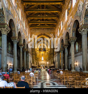 MONREALE, ITALY - JUNE 25, 2011: tourists in interior Duomo di Monreale in Sicily. The cathedral of Monreale is one of the greatest examples of Norman Stock Photo