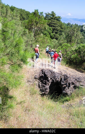 ETNA, ITALY - JULY 1, 2011 - tourists on overgrown slope over old crater of Etna volcano. Mount Etna is active volcano on the east coast of Sicily, th
