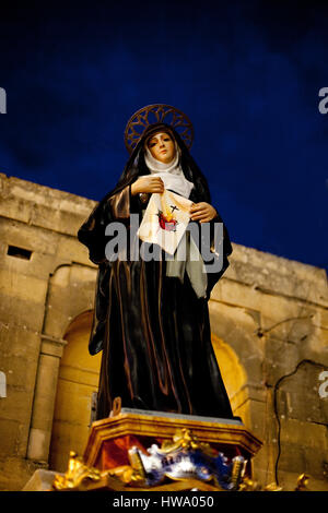 Female statue erected to celebrate the festifal of Jesus of the Sacred Heart in the evening Stock Photo