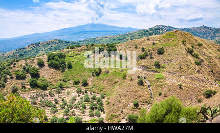 travel to Italy - panorama with green mountain slope and Etna mount near Calatabiano town in Sicily Stock Photo
