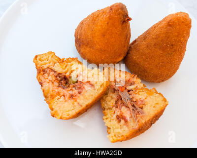 travel to Italy, italian cuisine - local meal arancini ( fried rice filled balls with filling coated with breadcrumbs) on white plate in Sicily Stock Photo