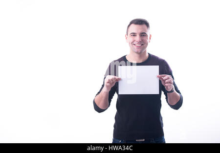 Young cheerful man holding a paper horizontally on white background Stock Photo