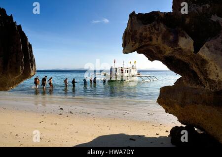 Philippines, Calamian Islands in northern Palawan, Coron Island Natural Biotic Area, Banul Beach, embarking on an outrigger canoe Stock Photo