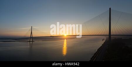 France, Calvados, Seine-Maritime, the Pont de Normandie spans the Seine to connect the towns of Honfleur and Le Havre, sunrise (aerial view) Stock Photo