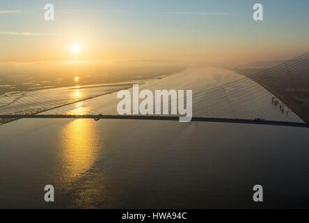 France, Calvados, Seine-Maritime, the Pont de Normandie spans the Seine to connect the towns of Honfleur and Le Havre, sunrise (aerial view) Stock Photo