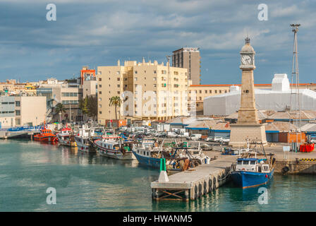 Boats moored in harbor at Port Vell in Barcelona, Spain. Sailboats, yachts, pleasure craft & fishing trawlers docked beside the city on warm afternoon Stock Photo