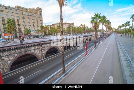 Barcelona, Spain, Nov 3rd, 2013:  Tourism in Spain.   Off season traffic in tunnelled streets & pedestrian traffic above as people enjoy warm outdoors Stock Photo