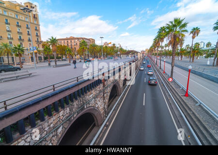 Barcelona, Spain, Nov 3rd, 2013:  Tourism in Spain.   Off season traffic in tunnelled streets & pedestrian traffic above as people enjoy warm outdoors Stock Photo