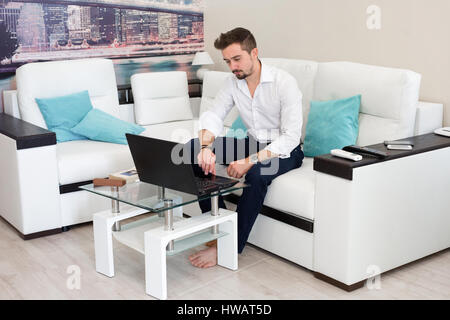 Surprised shocked man with opened mouth work at home with laptop Stock Photo