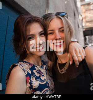 Lifestyle cute portrait of two best friends sister girls, hugs , having fun and posing on camera, stylish clothes and accessorizes, natural makeup,par