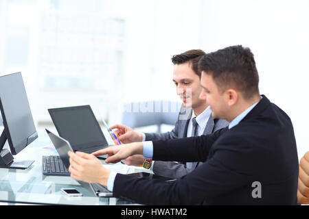 Two colleagues businessman discussing data and digital tablet and computer laptop with smart phone with digital business strategy on wooden desk as co Stock Photo