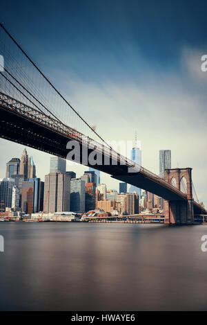 Below Brooklyn Bridge with downtown Manhattan skyline in New York City Stock Photo