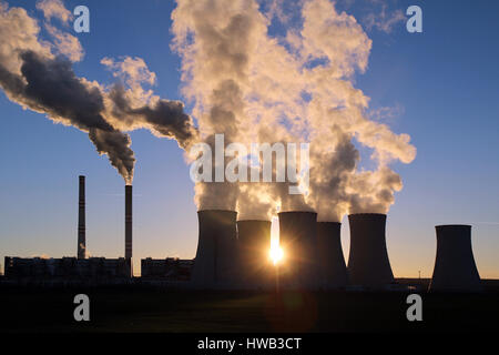 smoking cooling towers of coal power plant against the sun Stock Photo