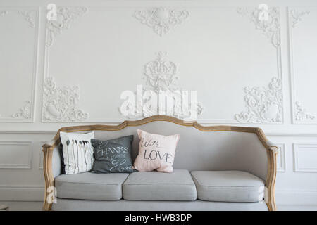 Beautiful Provance Living Room With Sofa over luxury wall decorated with stucco mouldings Stock Photo