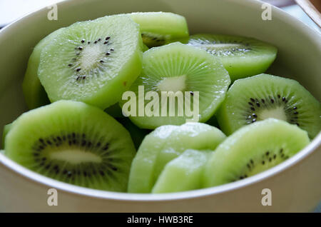 Slices of green kiwi fruit in a bowl. Stock Photo