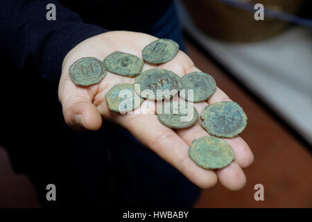 Bet Shemesh, Israel, 19th March: An Israeli archeologist showing s cache of nine bronze coins from the end of the Byzantine period (seventh century CE) at the National Treasures Storerooms of the Israel Antiquities Authority near the city of Bet Shemesh on 19 March 2017. Credit: Eddie Gerald/Alamy Live News