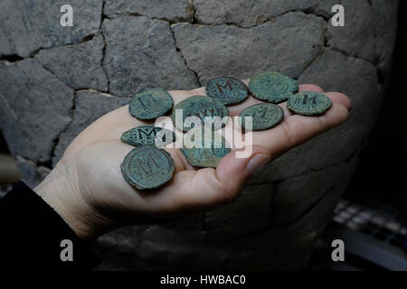 Bet Shemesh, Israel, 19th March: An Israeli archeologist showing s cache of nine bronze coins from the end of the Byzantine period (seventh century CE) at the National Treasures Storerooms of the Israel Antiquities Authority near the city of Bet Shemesh on 19 March 2017. Credit: Eddie Gerald/Alamy Live News