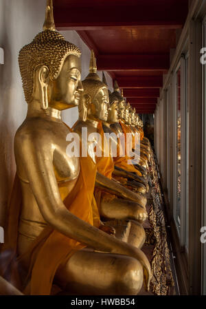 Bangkok, Thailand. 14th Nov, 2006. A row of golden Buddha statues sit in the cloister of Wat Suthat temple in Bangkok, a famous royal temple of the first grade. Thailand has become a favorite tourist destination. Credit: Arnold Drapkin/ZUMA Wire/Alamy Live News Stock Photo